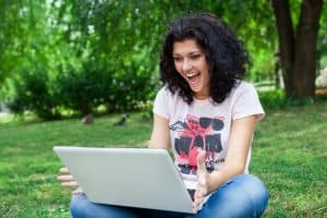 A lady happy staring at her laptop