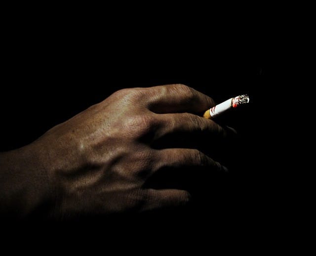 a man holding cigarettes 