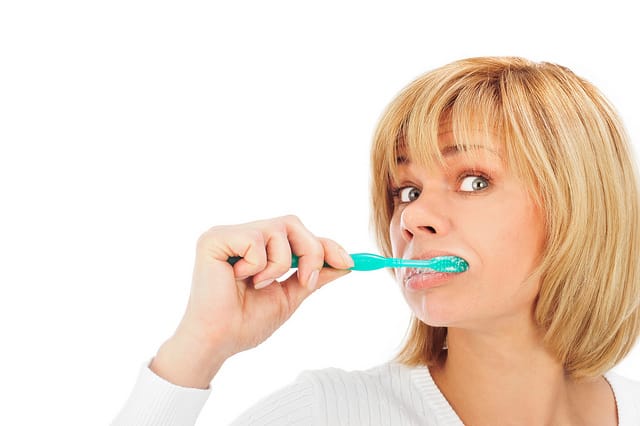 Detail portrait of a happy mature woman brushing her teeth